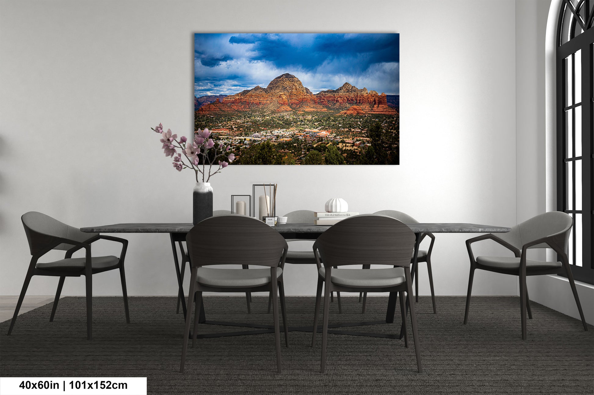 a dining room table with chairs and a painting on the wall