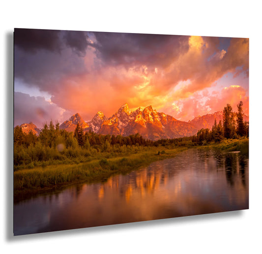 a beautiful sunset over a mountain range with a river in the foreground
