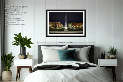 a bedroom with a bed and a night view of a city