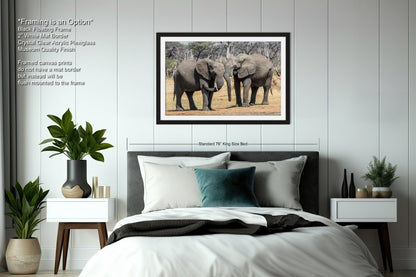 a couple of elephants standing next to each other on a bed