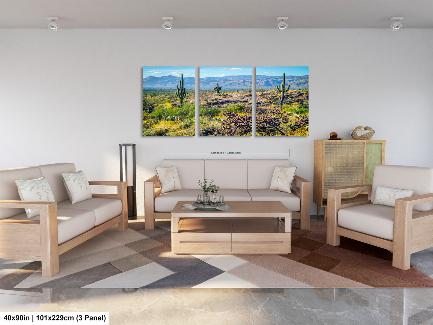 The image is a modern living room with a large, three-panel landscape painting depicting a desert scene with cacti and mountains in the background. The room is furnished with a sofa, two armchairs, and a coffee table, creating a comfortable and inviting atmosphere.