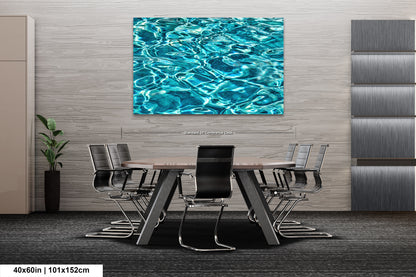 a modern office space with a large abstract painting of water on the wall above a conference table surrounded by chairs.