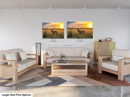 a living room with a large sofa, two chairs, and a coffee table. There are two framed prints of a sunset landscape on the wall above the furniture.