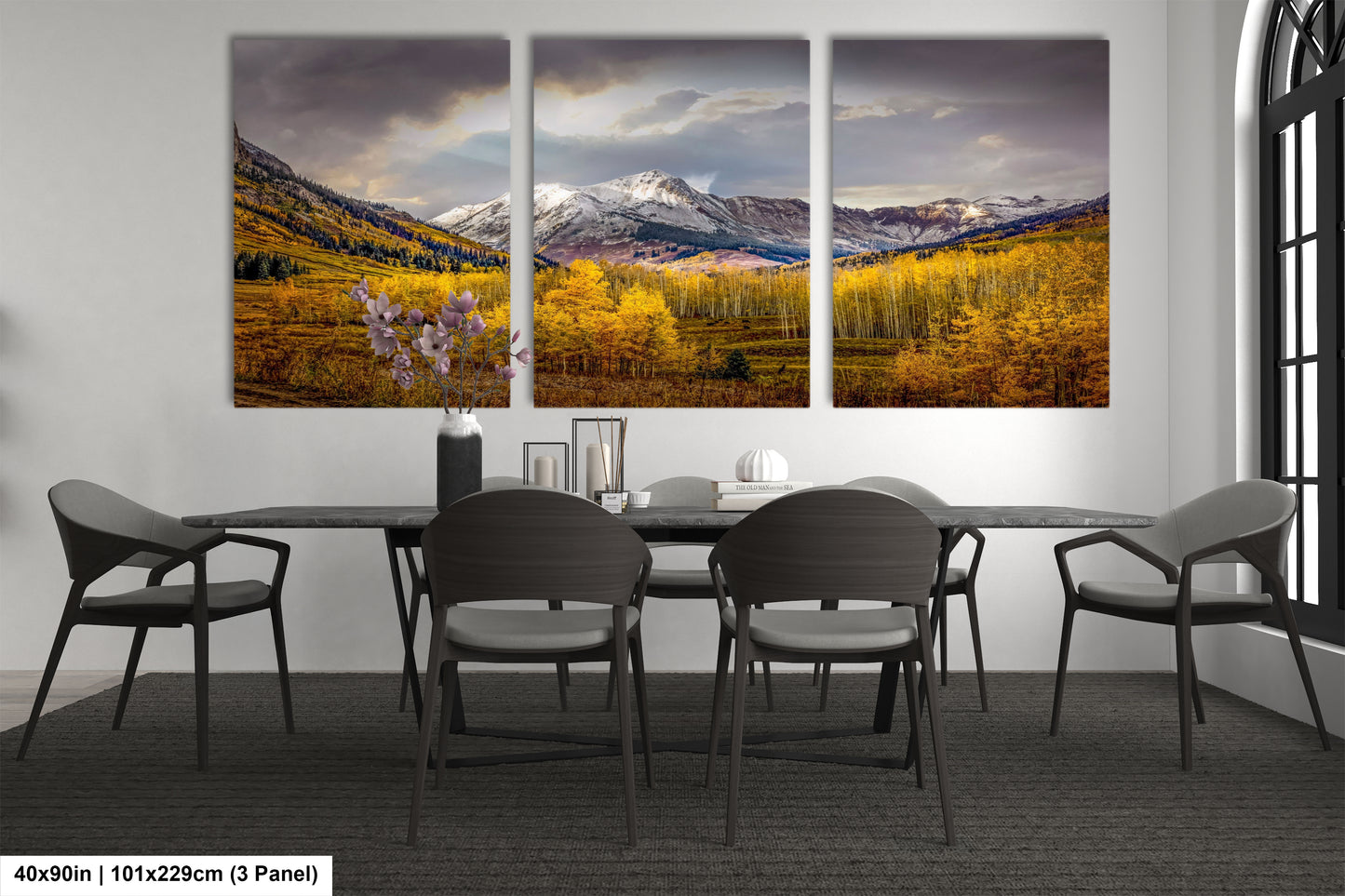 a dining room table with four chairs and three paintings on the wall