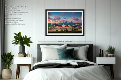 a bedroom with a large bed and a picture hanging above it
