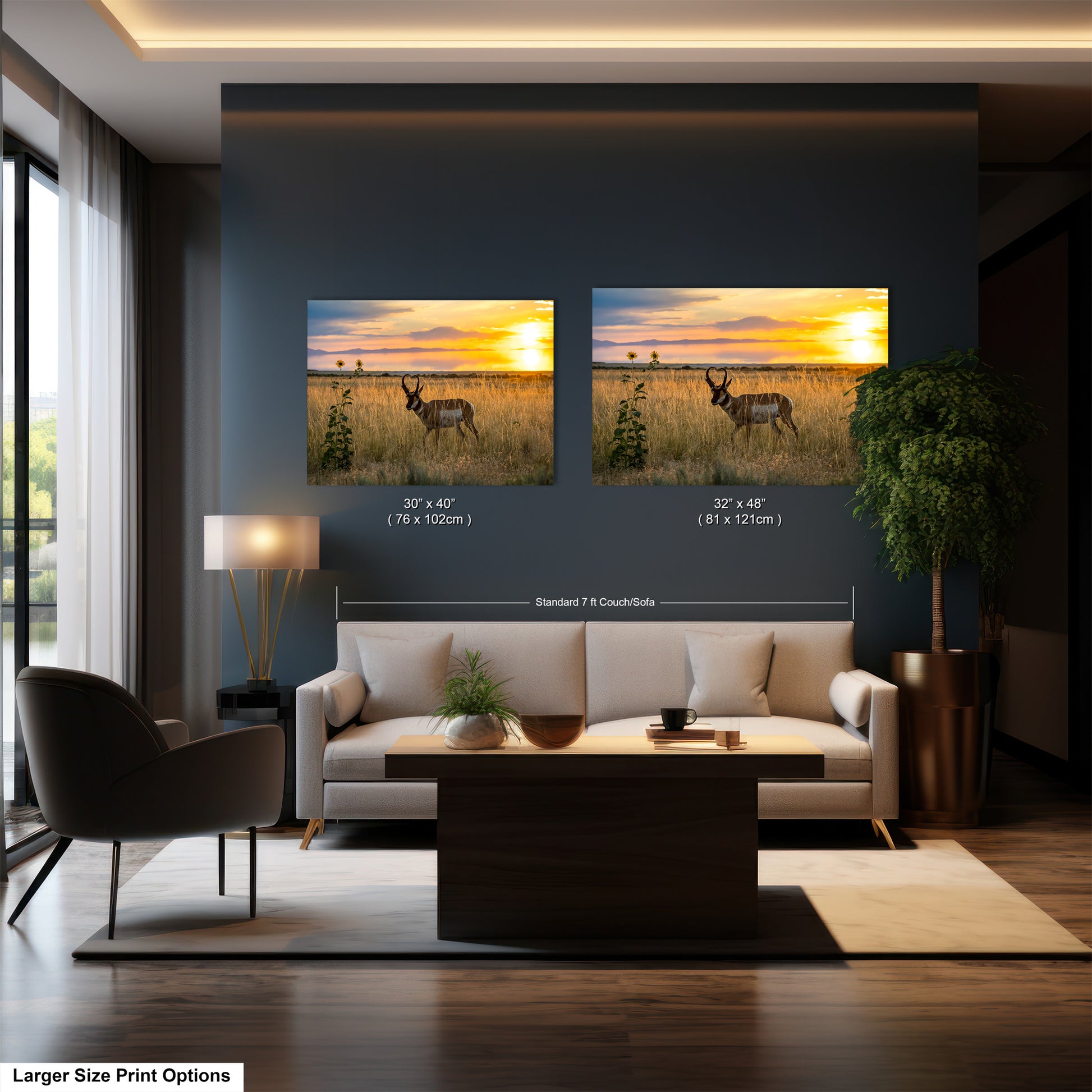 a living room with a large sofa, a coffee table, and a lamp. Above the sofa, there are two framed pictures of a deer in a field at sunset. The pictures are of the same size and are displayed side by side on the wall.