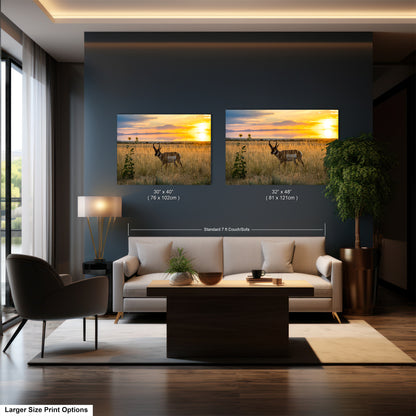 a living room with a large sofa, a coffee table, and a lamp. Above the sofa, there are two framed pictures of a deer in a field at sunset. The pictures are of the same size and are displayed side by side on the wall.