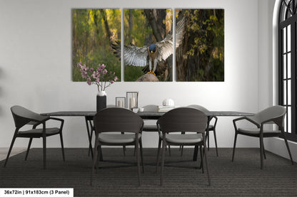A modern dining room with a large wall-mounted painting depicting a bird in flight. The painting is composed of three panels, with the bird in the center and its wings spread wide. The room is furnished with a black table and chairs, and there is a vase of flowers on the table. The overall design and decor create a sleek and contemporary atmosphere.