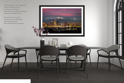 a dining room table with chairs and a picture hanging above it