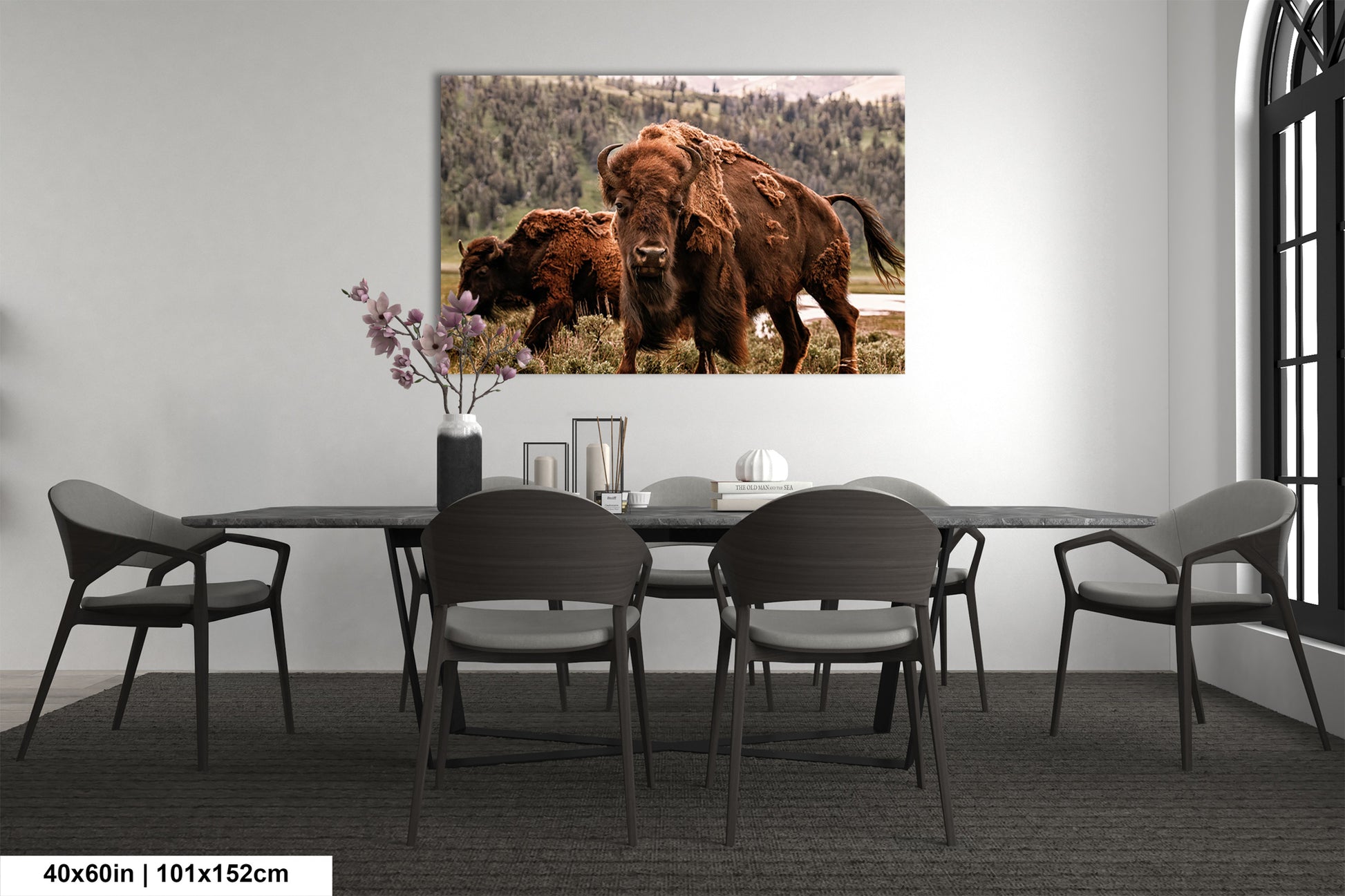 a dining room table with chairs and a picture of a bison on the wall