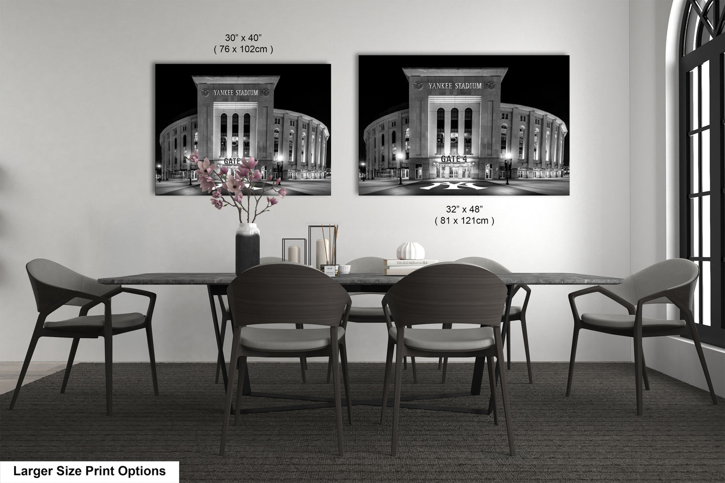 a dining room with a large dining table and chairs. There are two framed black and white photographs of Yankee Stadium hanging on the wall above the table.