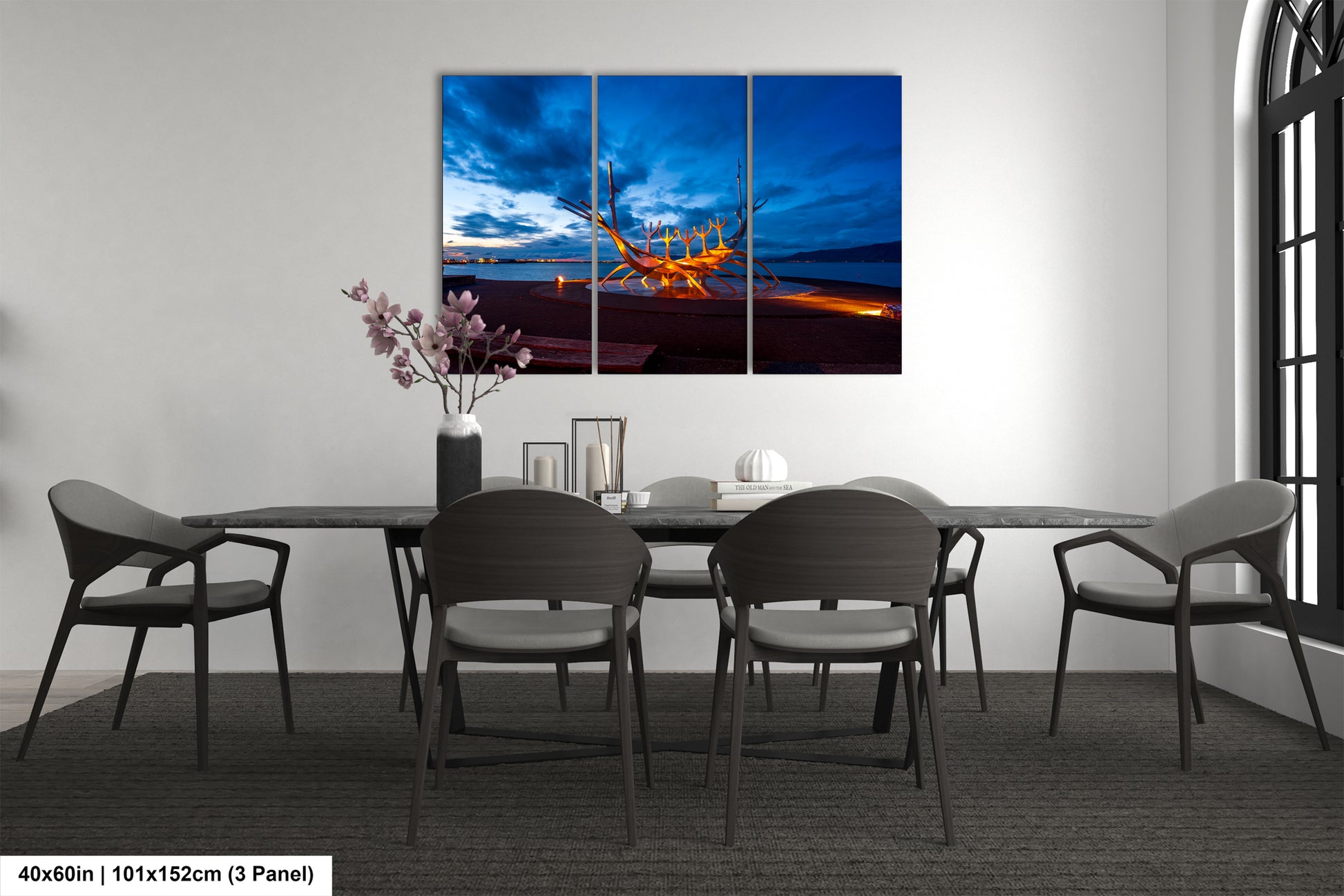 a dining room table with chairs and a painting on the wall