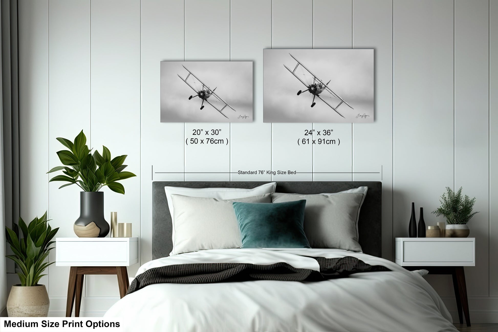 a bed with a white comforter and two pictures on the wall above it