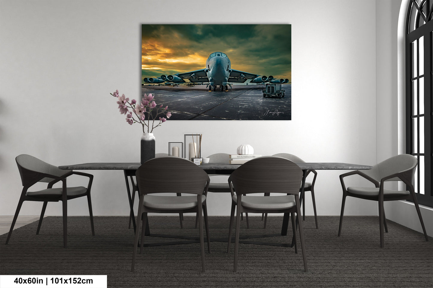 a dining room table with chairs and a painting on the wall