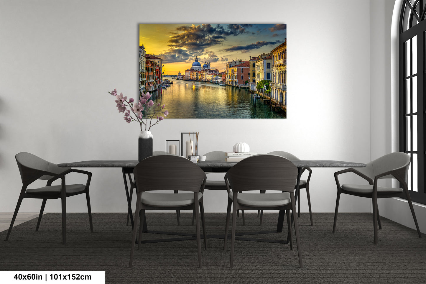 a dining room table with chairs and a painting on the wall