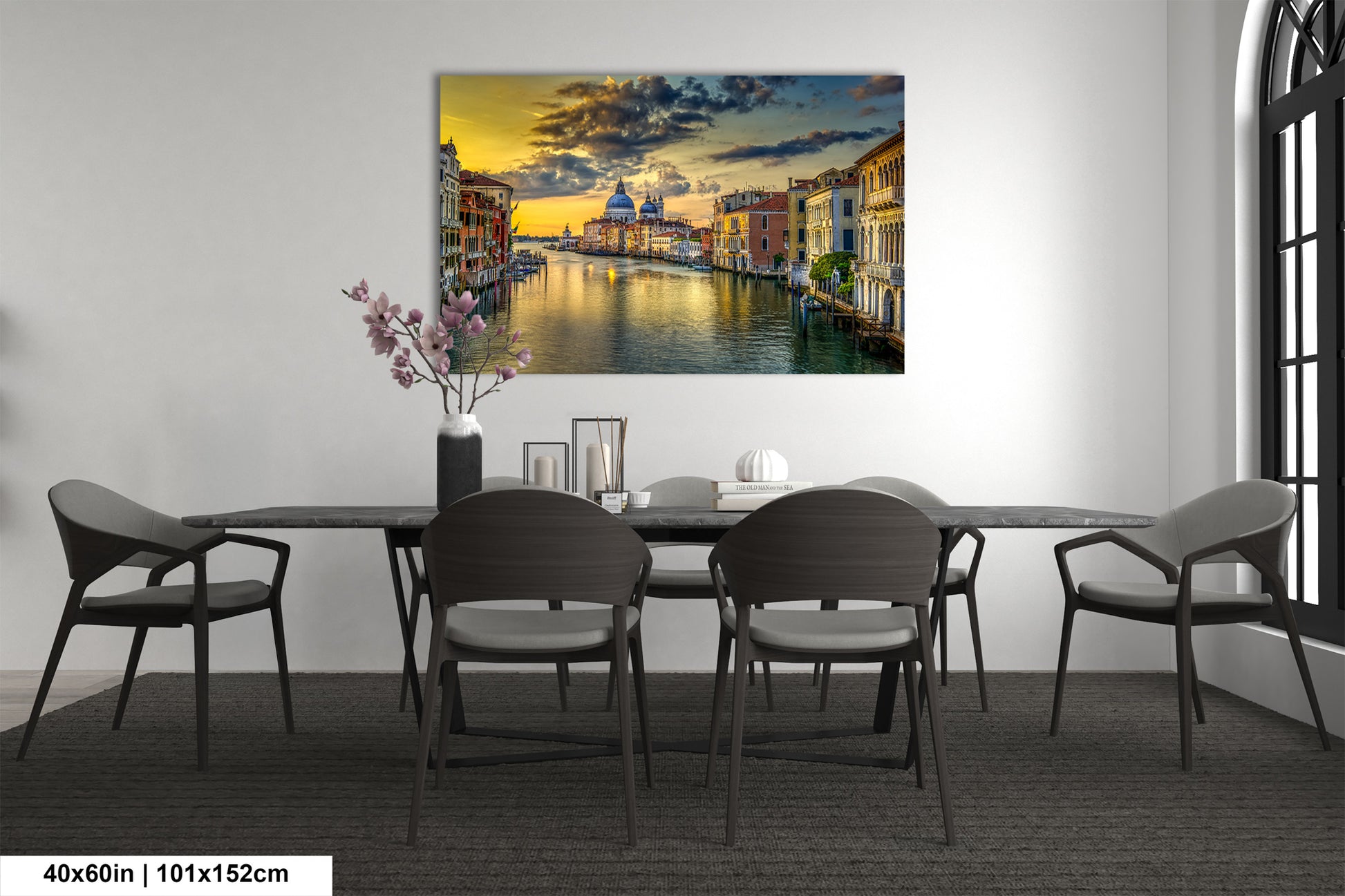 a dining room table with chairs and a painting on the wall
