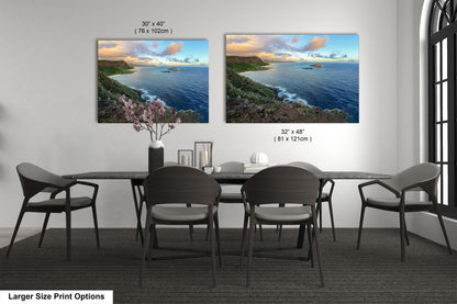 a dining room table with four chairs and two pictures on the wall
