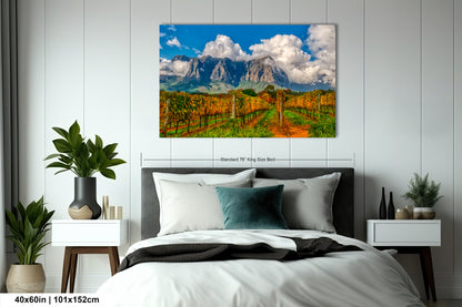 a bed room with a neatly made bed and a painting on the wall