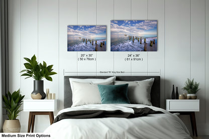 a bed room with a neatly made bed and two pictures on the wall