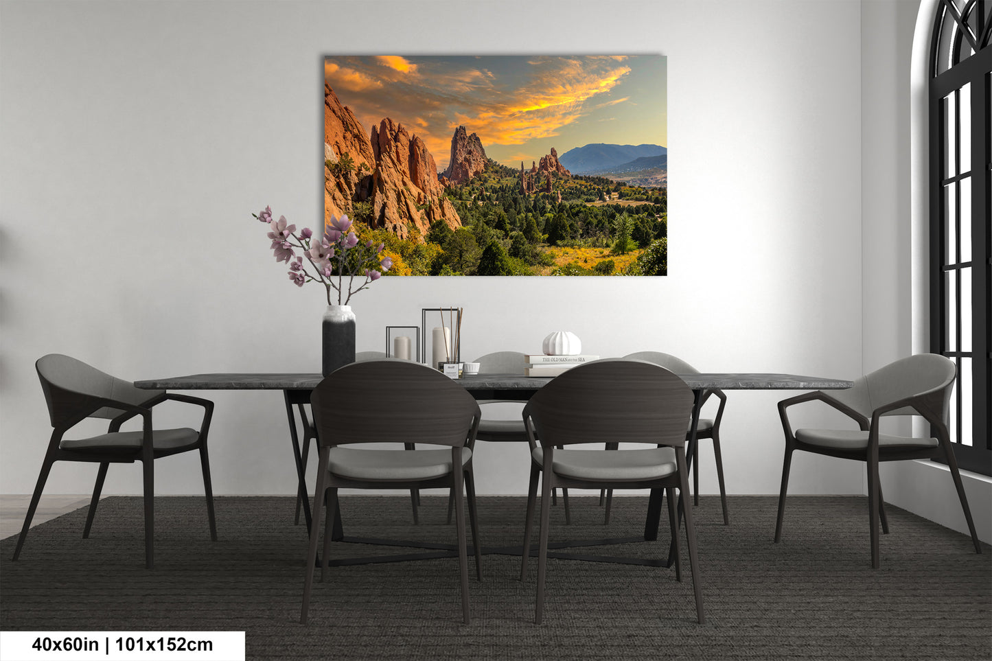 a dining room table with chairs and a painting on the wall