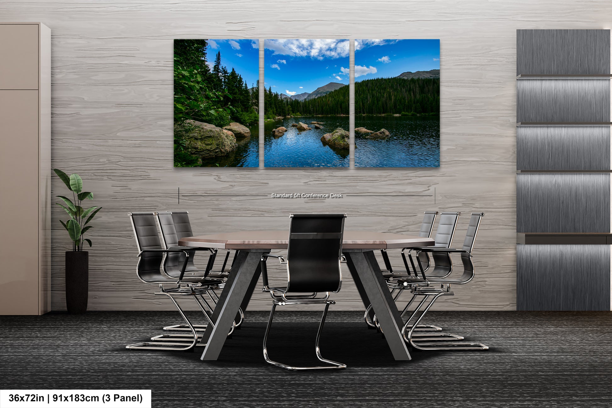 A modern office space with a large, three-panel landscape painting depicting a serene lake surrounded by mountains and trees. The painting is mounted on a gray wall above a wooden table with chairs.