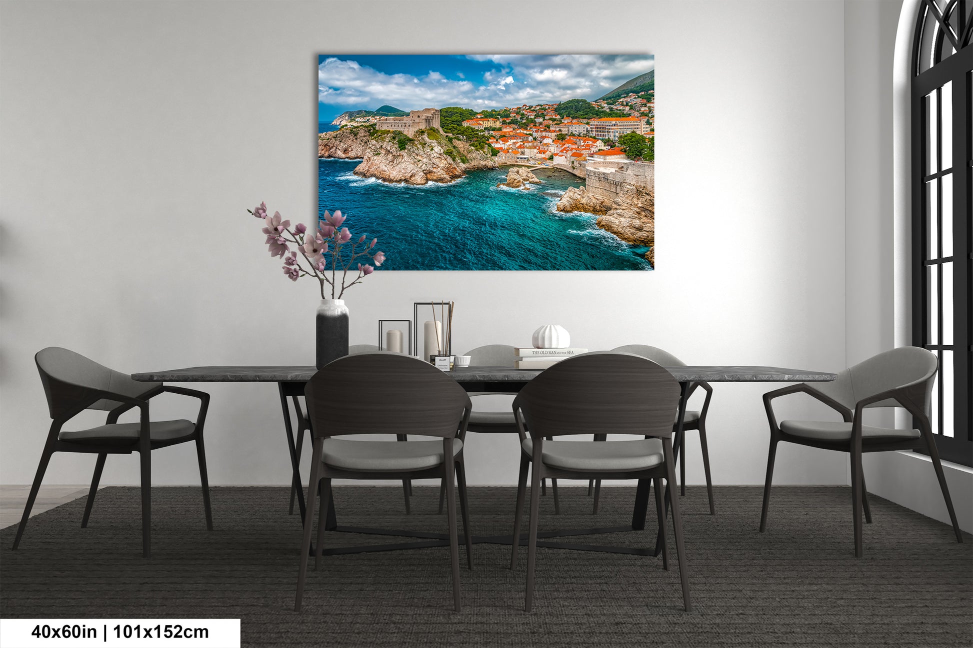 a dining room table with chairs and a painting on the wall