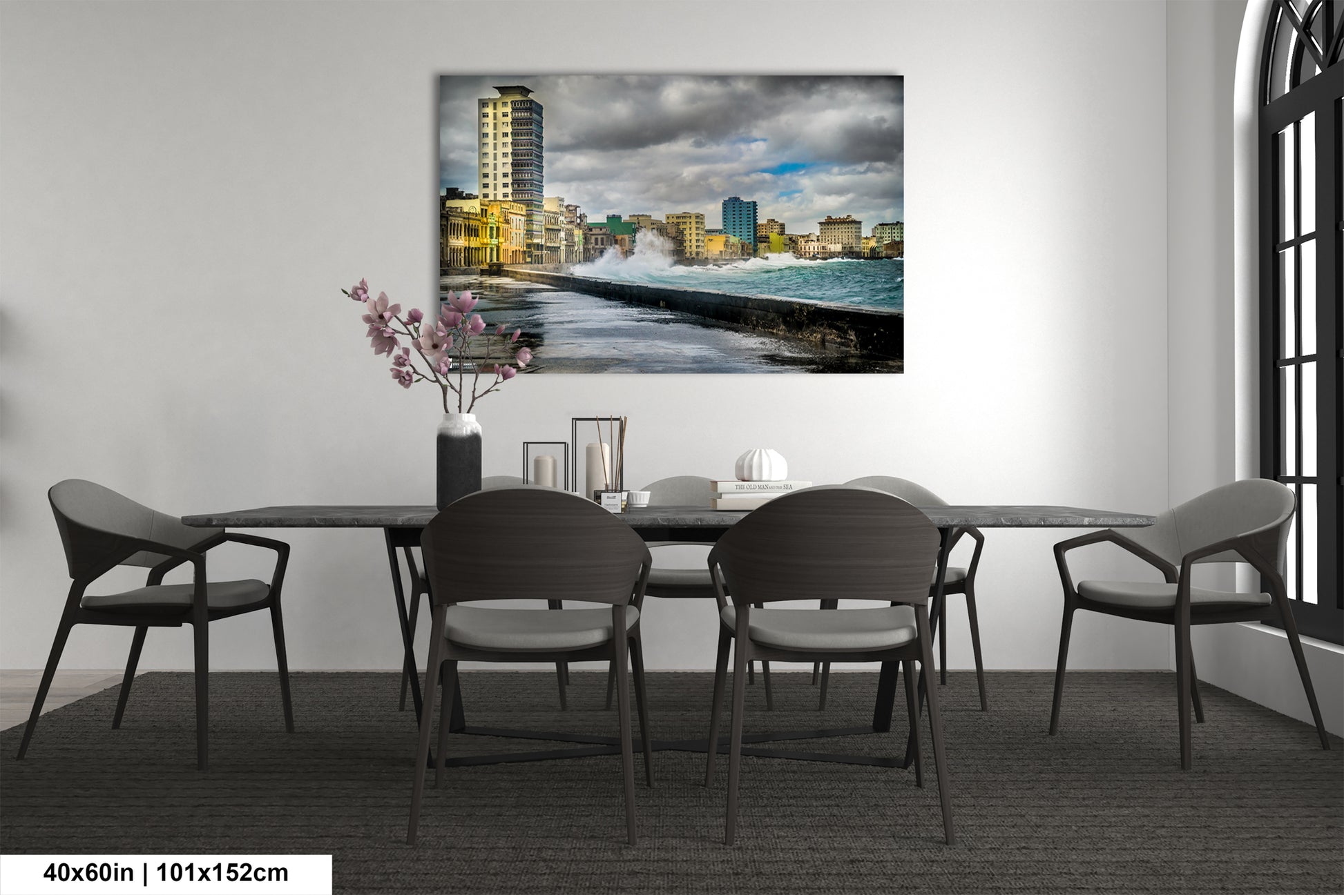 a dining room table with chairs and a painting on the wall