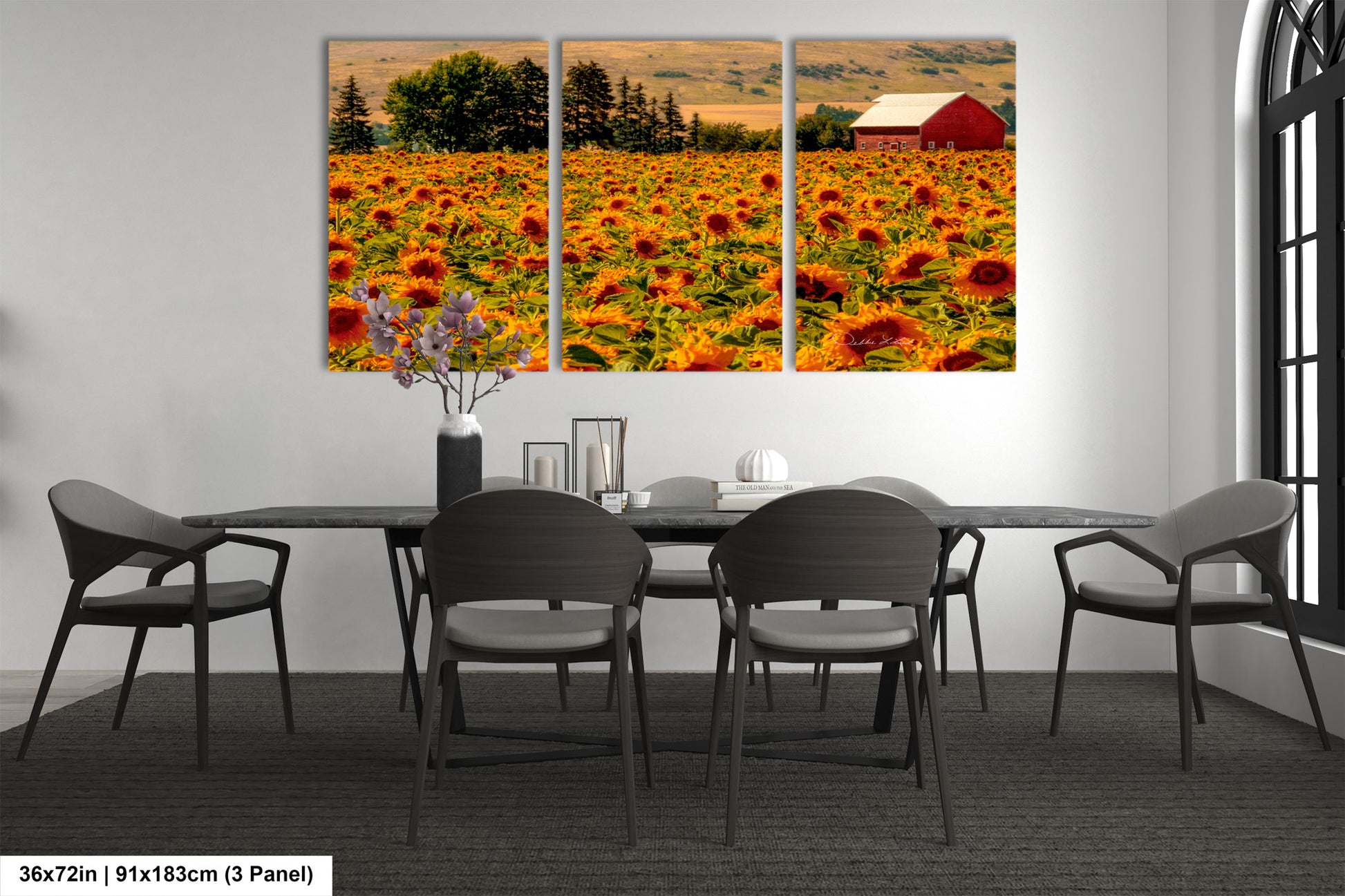 a dining room with a table and chairs and a picture of a sunflower field
