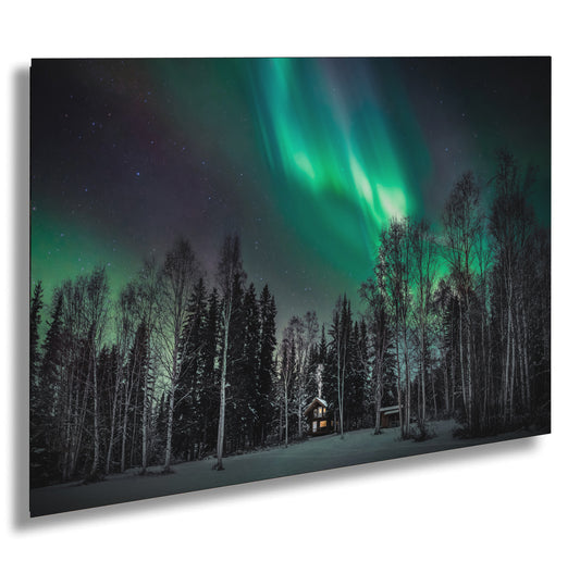 a cabin in the woods under a green aurora bore