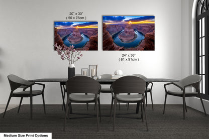 a dining room table with four chairs and two pictures on the wall