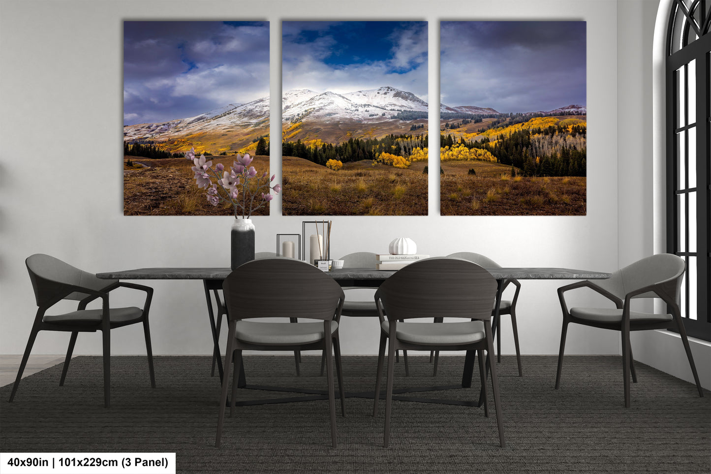 a dining room table with four chairs and three paintings on the wall