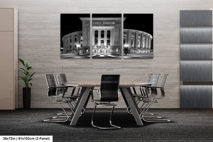 A modern office space with a large black and white photograph of the Yankee Stadium in New York City hanging on the wall. The photograph is composed of three panels, and the image is described as a collage of multiple images.