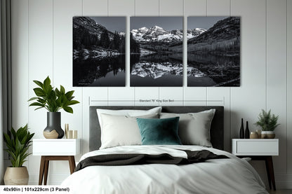 a black and white photo of a bedroom with mountains in the background
