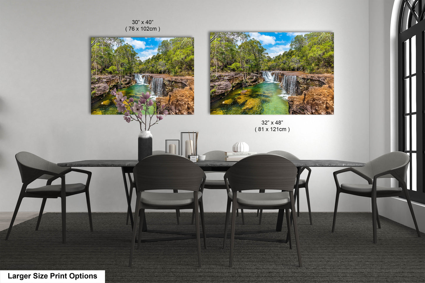 a dining room table with four chairs and a painting of a waterfall