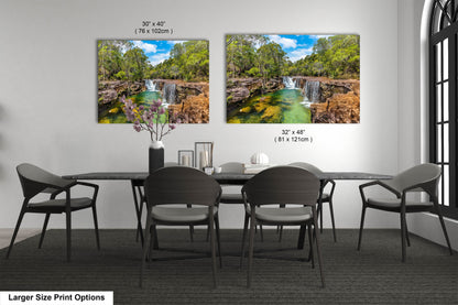 a dining room table with four chairs and a painting of a waterfall