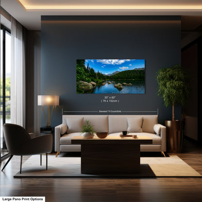 A modern living room with a large framed landscape painting depicting a serene mountain lake scene hanging on the wall.