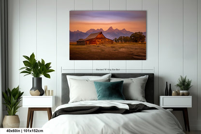 a bed in a room with a painting on the wall