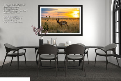 a modern dining room with a large framed picture of a sunset over a field hanging on the wall above a black dining table with four chairs.