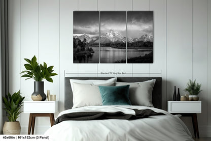 a black and white photo of a bed with a mountain range in the background
