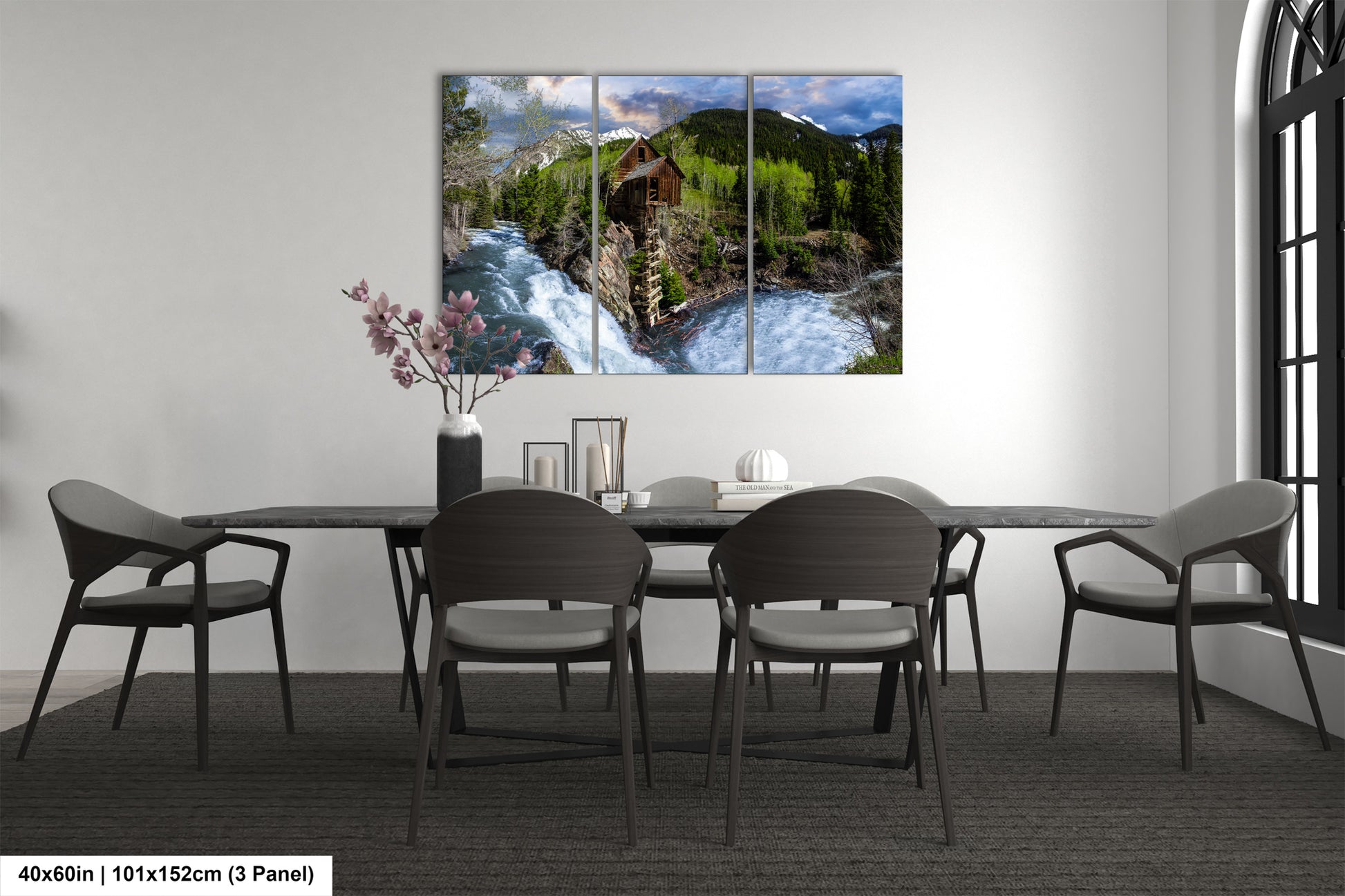 a dining room table with chairs and a painting on the wall