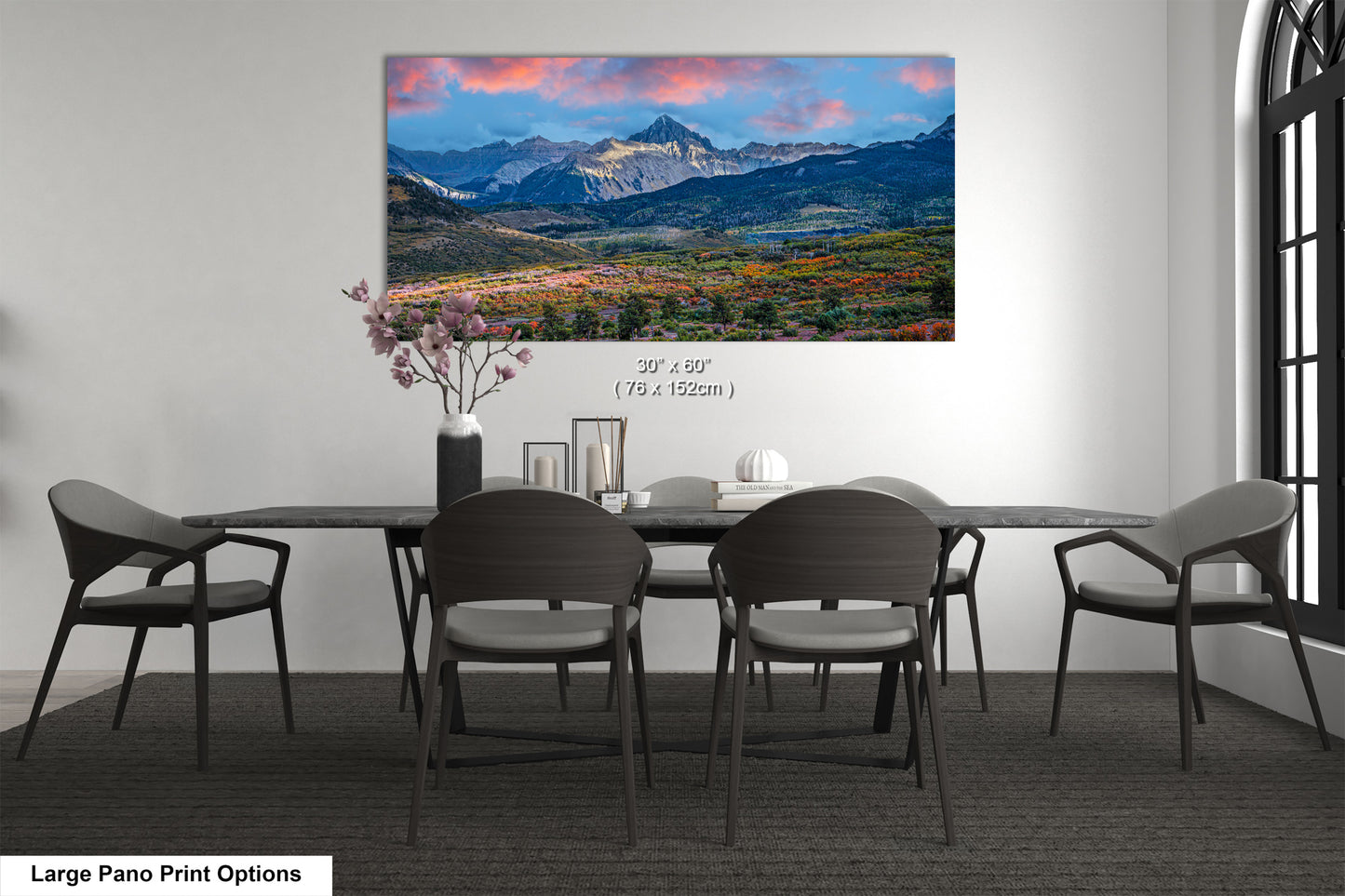 a dining room table with chairs and a painting on the wall