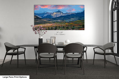 a dining room table with chairs and a painting on the wall