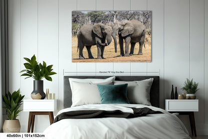 a couple of elephants standing next to each other on a bed