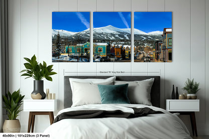 a bedroom with a large bed and three paintings on the wall