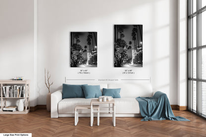 a living room with a white couch and two pictures on the wall