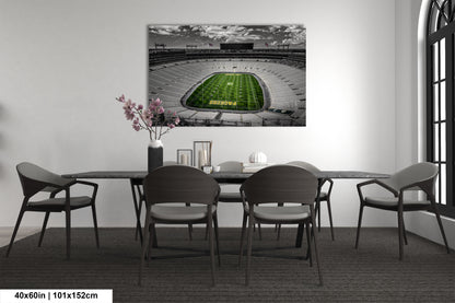 a dining room table with chairs and a painting of a football stadium