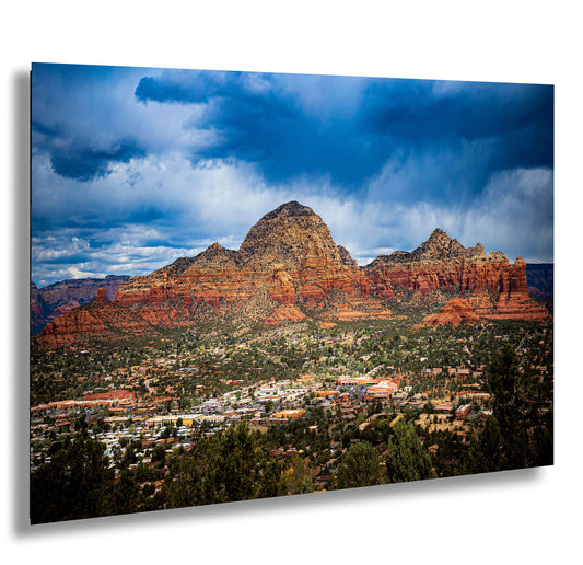 a scenic view of a city and mountains under a cloudy sky