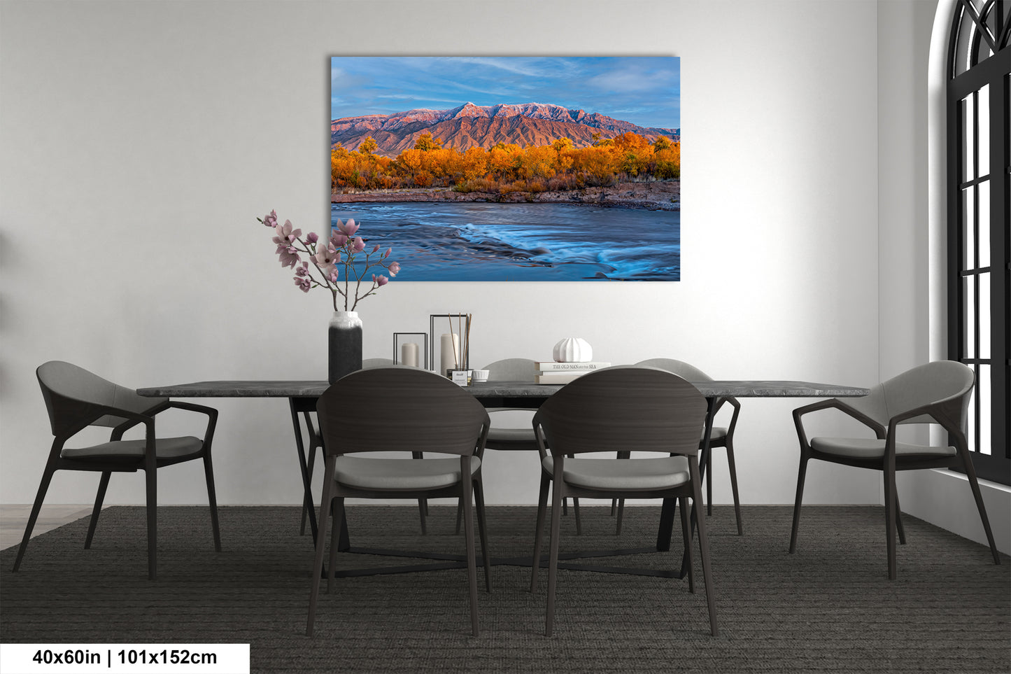 a dining room table with chairs and a painting on the wall