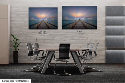 a dining room table with chairs and two pictures on the wall