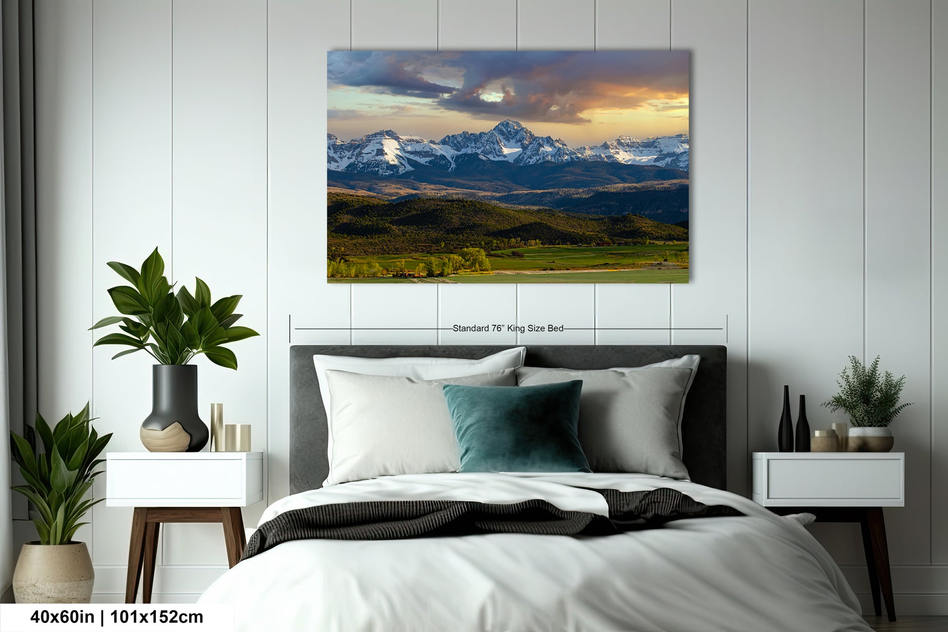 a serene mountain landscape with snow-capped peaks and a vibrant sky, featuring a large, detailed painting of the scene above a bed with white linens and a gray headboard.
